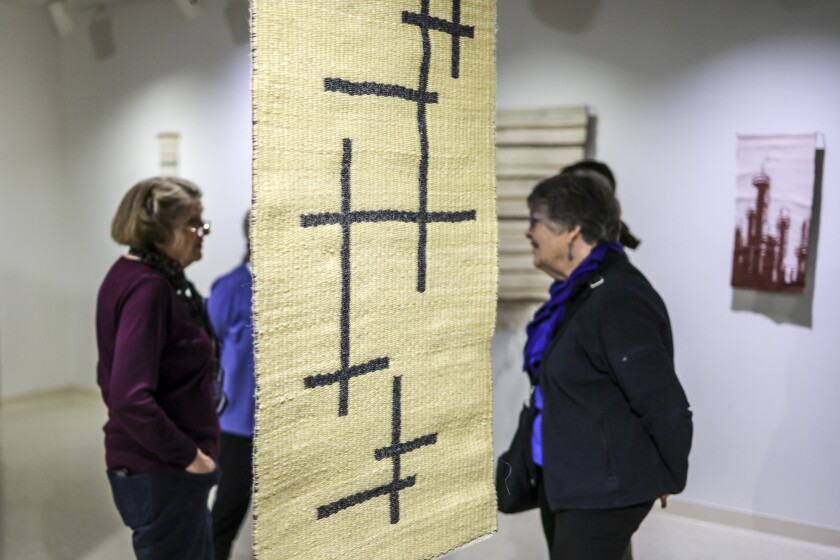 women looking at fiber art in gallery