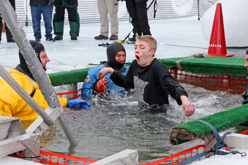 People jump into the water during the Polar Plunge event on Pelican Lake.