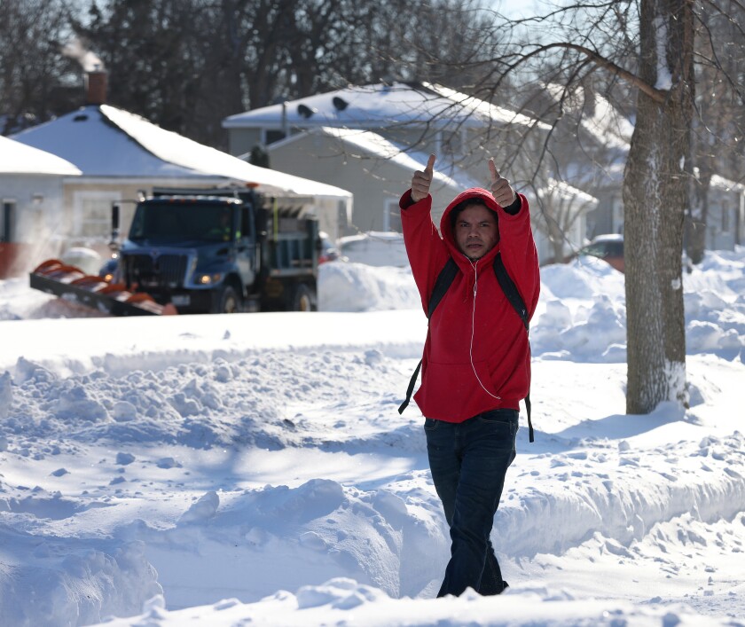 A Worthington resident gives two thumbs up for a beautiful sunshiny day as a snow plow widens Grand Avenue Thursday, Jan. 5, 2023.