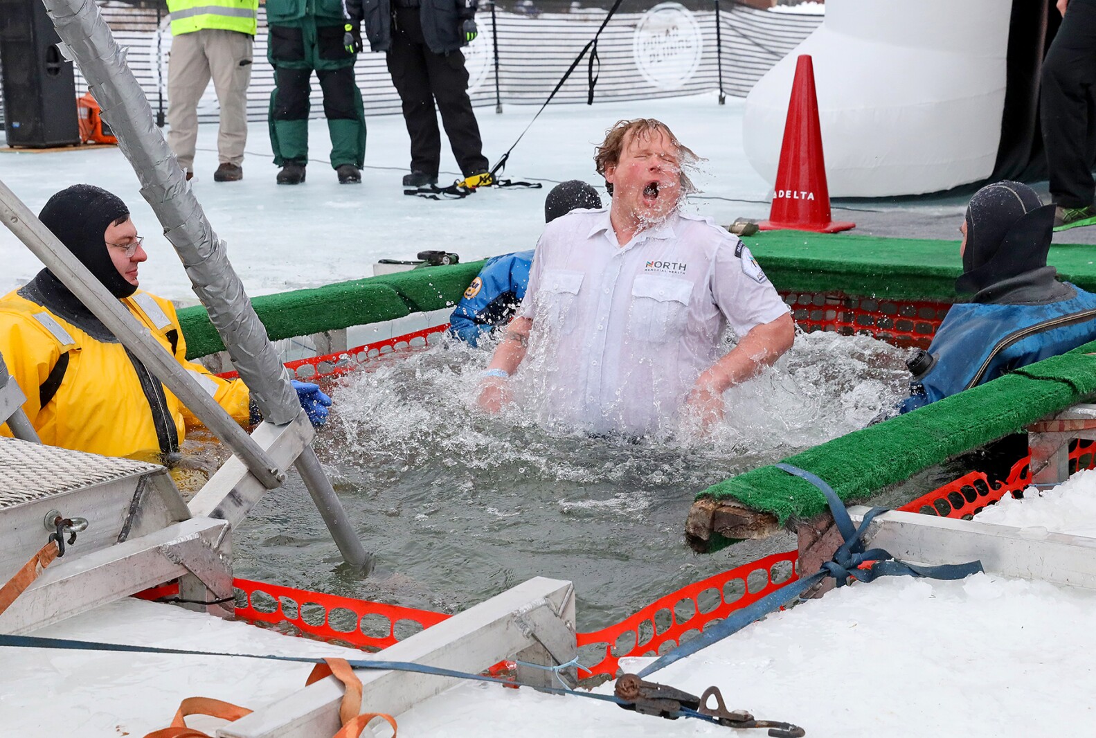 People jump into the water during the Polar Plunge event on Pelican Lake.