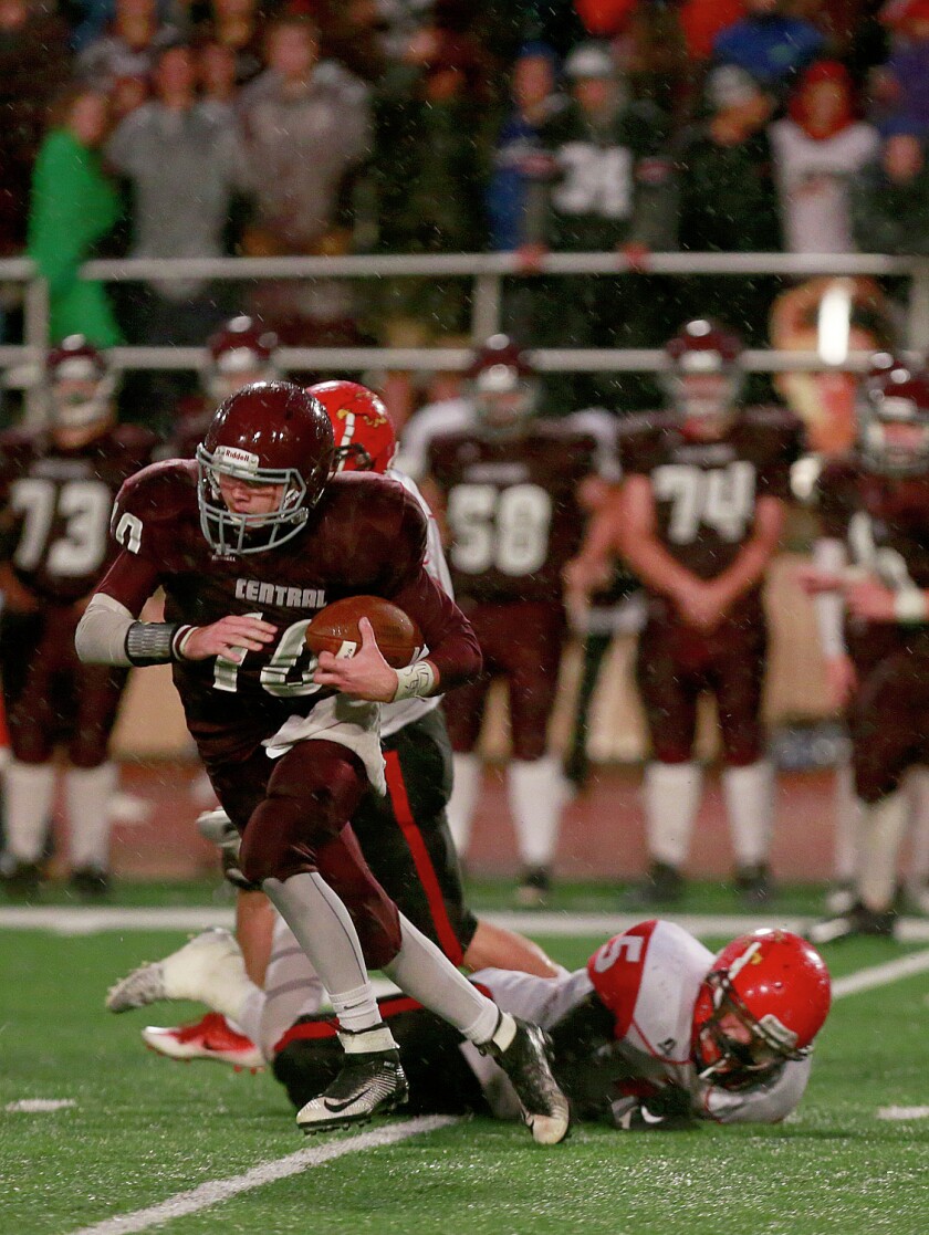 Grand Forks Central quarterback Zack Murphy slips a tackle as he runs for a first down late in the first half of the Knights game with Devils Lake at Cushman Field. photo by Eric Hylden/Grand Forks Herald