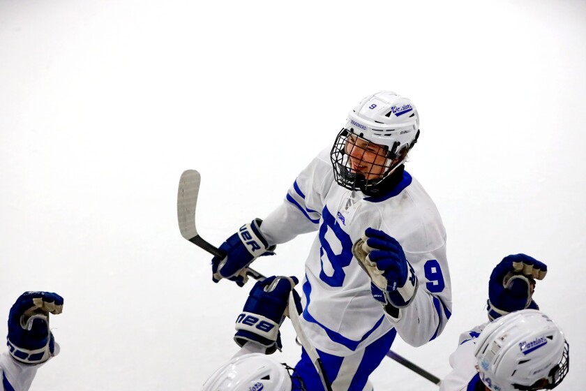 A player gets high fives from his teammates as he skates past them.