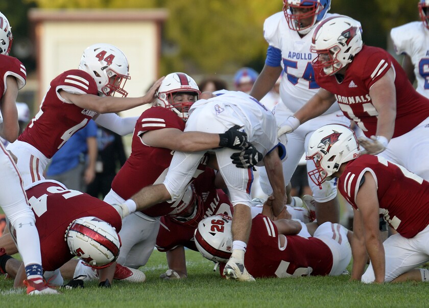 Willmar senior Marlon Fernandez-Muñoz, center, and Cardinals defenseman tackle St. Cloud Apollo's Will Allenspach during a North Central White District game on Friday, Sept. 2, 2022 at Hodapp Field in Willmar .