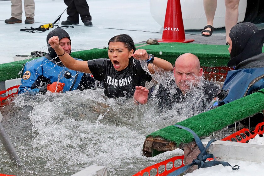 People jump into the water during the Polar Plunge event on Pelican Lake.