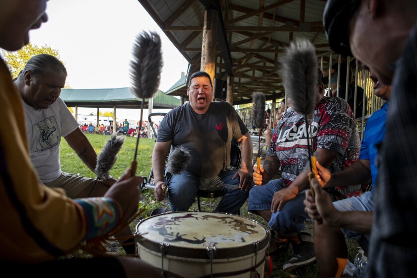 Robert Gill, center, of Sisseton, South Dakota, is joined by fellow Native Americans as they provide song for the Upper Sioux Community's traditional WACIPI on the evening of Friday, August 5, 2022.