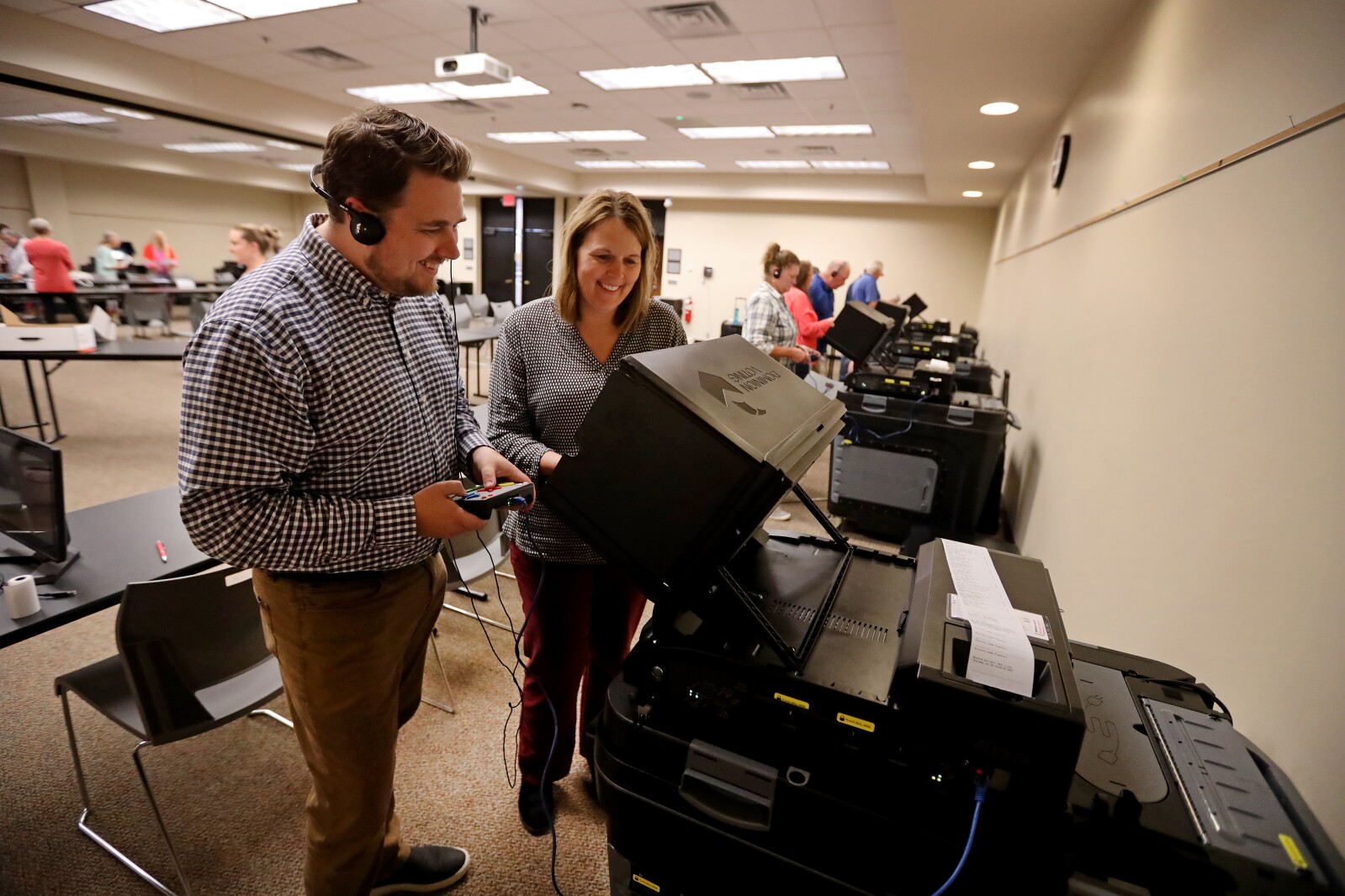 Two election judges test voting equipment.