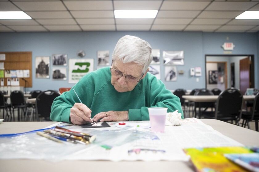 Fran Syverson adds dabs of red paint to a rose while working at the Little Art Gallery rally at the Willmar Community Center on Tuesday, April 12, 2022.