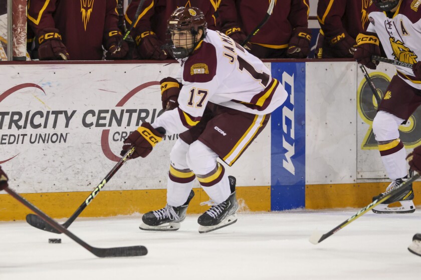 College hockey player play in indoor rink