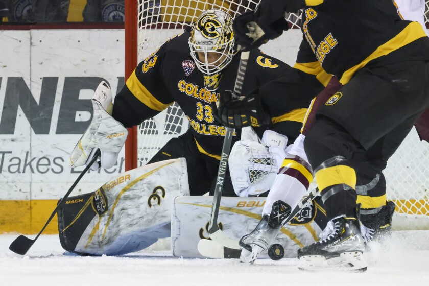 men's hockey players compete in game at indoor arena