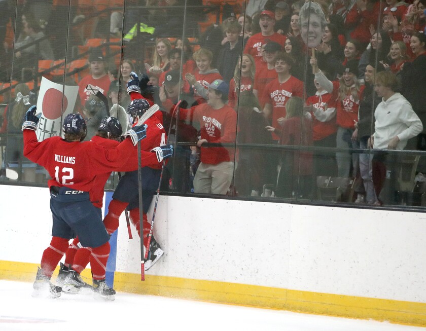 Superior’s Caden Lia (4) jumps into the board in front of the Spartan student section to celebrate his first period goal