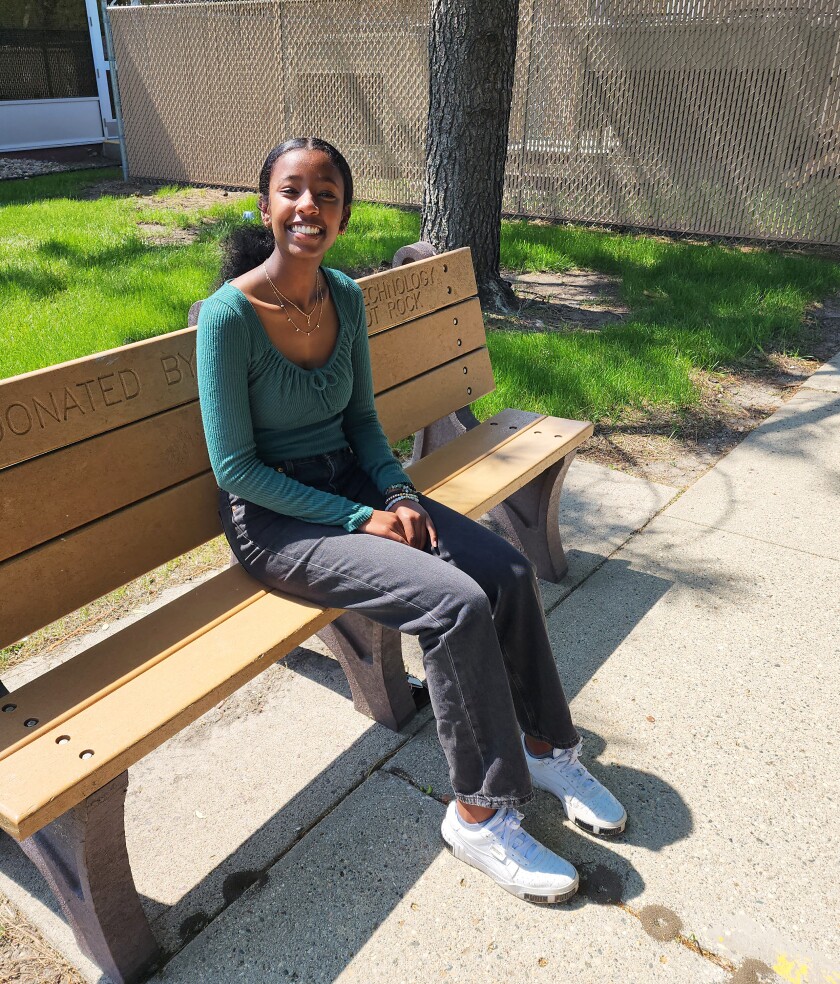 Root Gebremariam sits in the shade on a bench outside the Nobles County Library in Worthington.