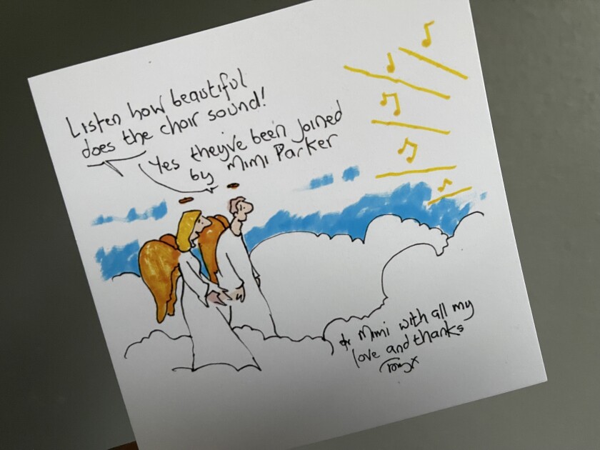 A cartoon printed on a white card has two angels standing on a cloud. One says, "Listen how beautiful does the choir sound!" The other replies, "Yes they've been joined by Mimi Parker."