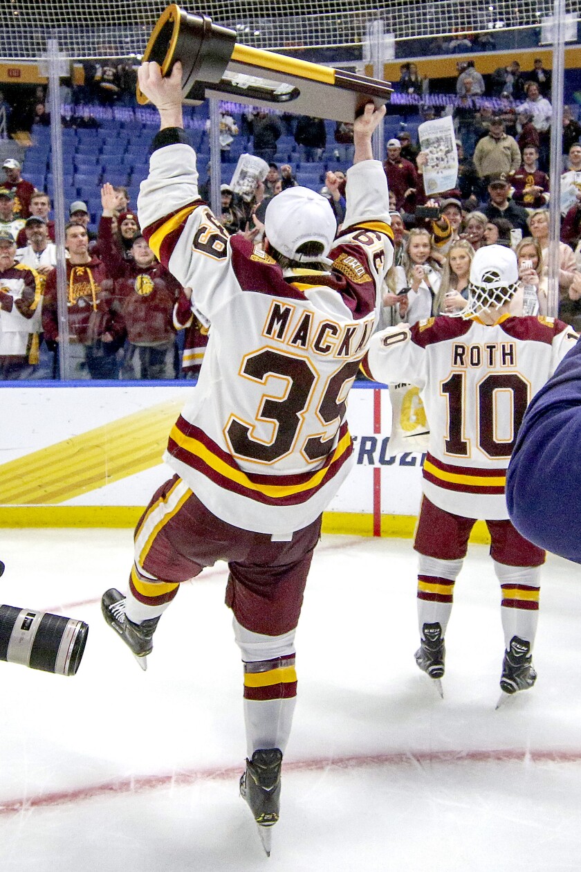 Minnesota Duluth's Parker Mackay celebrates with the championship trophy after the Bulldogs defeated Massachusetts 3-0 on Saturday night at KeyBank Center in Buffalo, N.Y. (Clint Austin / caustin@duluthnews.com)