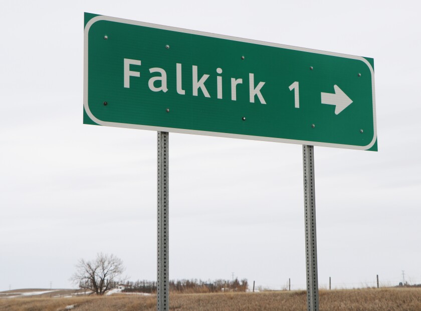 A green highway sign says it is 1 mile to Falkirk, North Dakota.