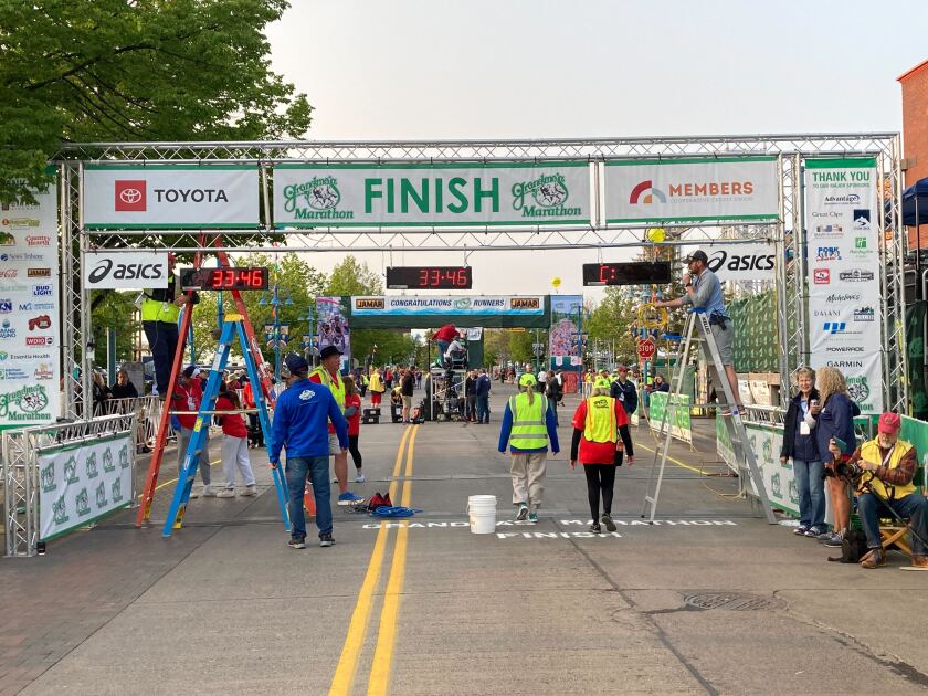 People in yellow reflective vests mill around finish line