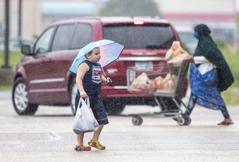 A young boy carries his umbrella to stay dry while walking to Cub Foods in Willmar on the morning of Friday, August 19, 2022. Despite rain late in the work week, forecasts are calling for sunny weather this weekend into early next week.