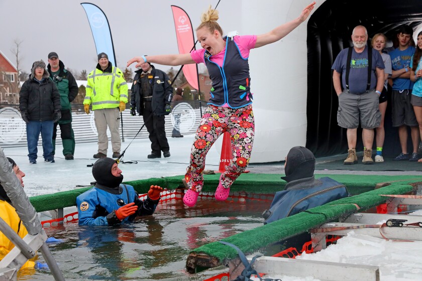 People jump into the water during the Polar Plunge event on Pelican Lake.