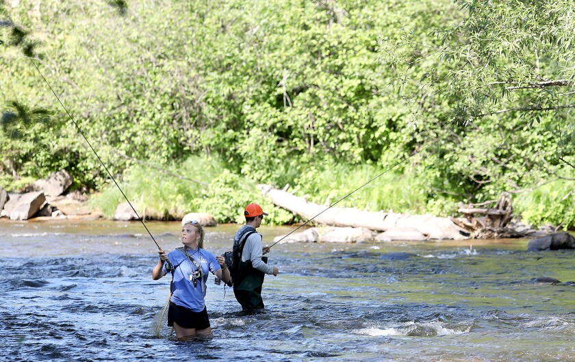 Maddie Kraemer, left, looks back at her line as she gets ready to cast while Travis Johnson works a spot