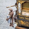 small, brown, ornate instrument with plush monkey holding coin container, hanging on side