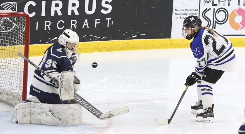 Proctor/Hermantown’s Izy Fairchild (27) shoots the puck at Hibbing goalie Addison Hess (30)