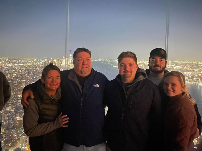 A family of 5 pose for a photo