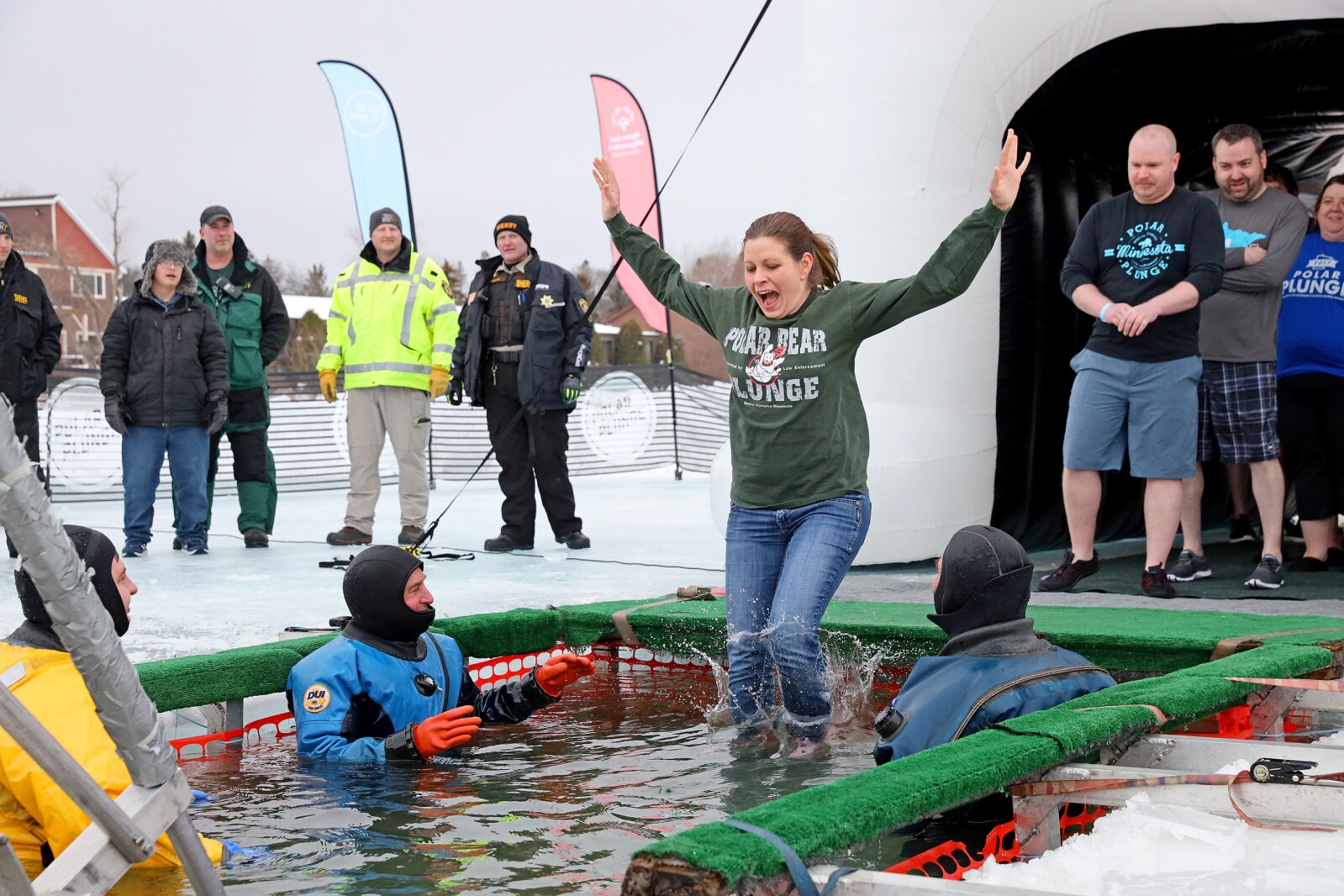 People jump into the water during the Polar Plunge event on Pelican Lake.
