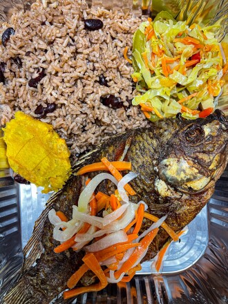 An Island Cuisine dish, pictured above, features fried tilapia fish with Haitian rice and steamed cabbage.