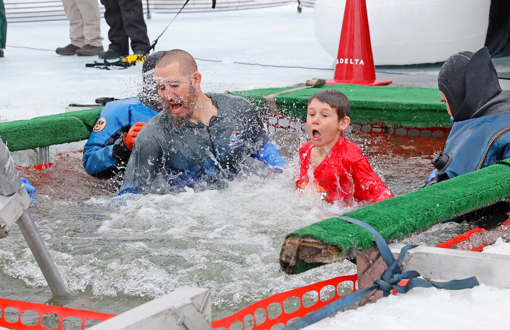 People jump into the water during the Polar Plunge event on Pelican Lake.