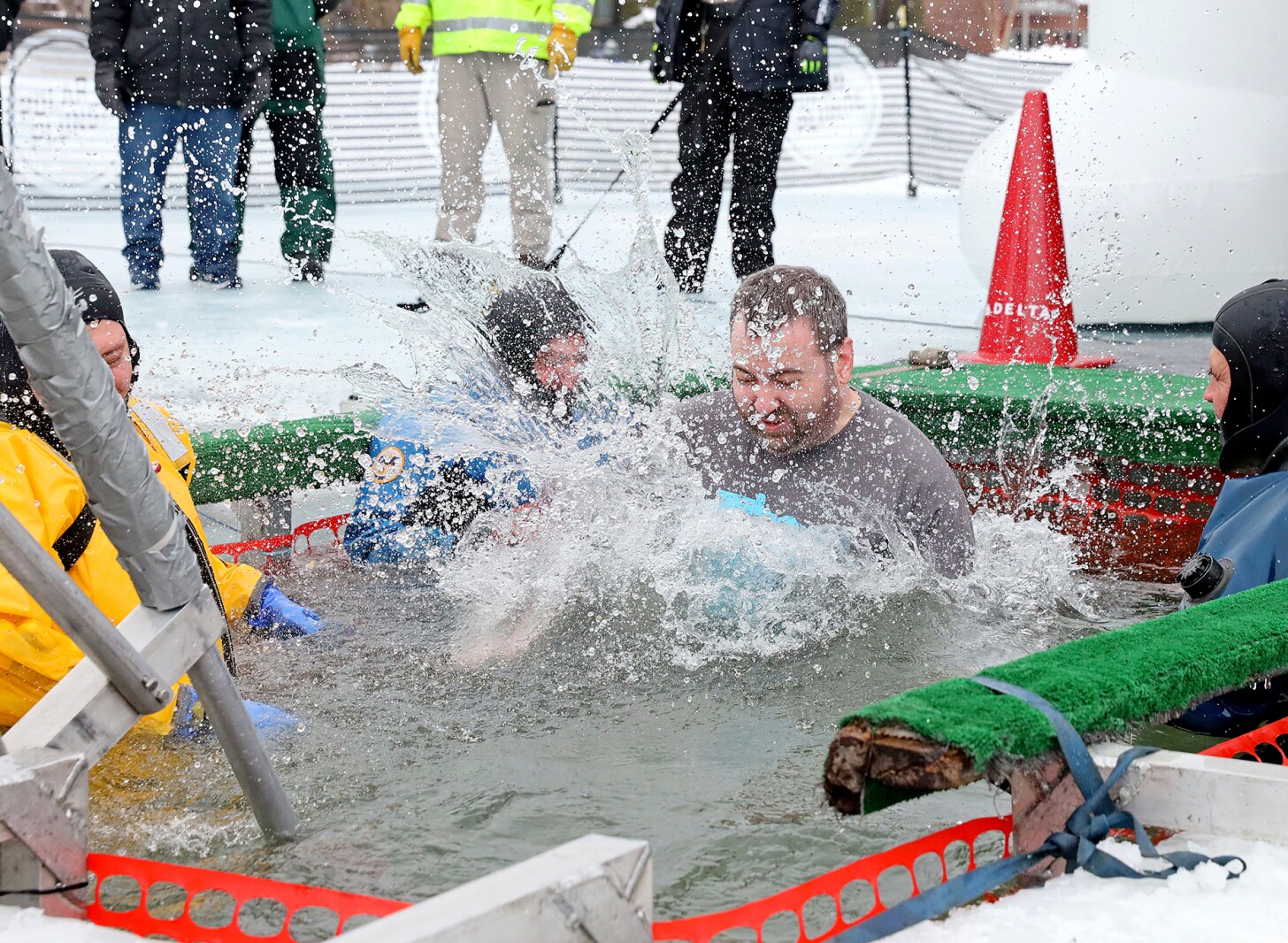 People jump into the water during the Polar Plunge event on Pelican Lake.