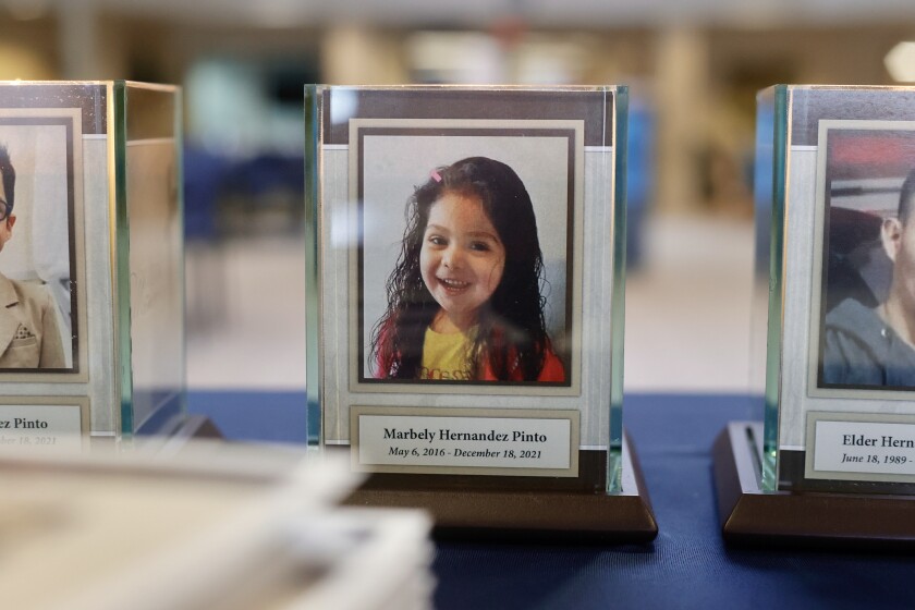 A plaque and candle with a portrait of Marbely Hernandez Pinto.