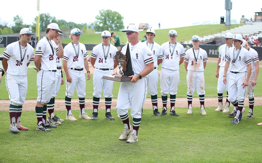 Coach holds up trophy.