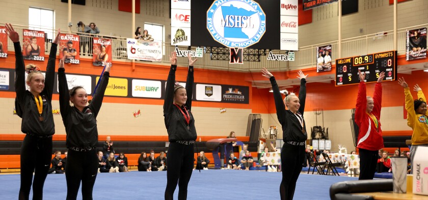 Worthington Trojans (from left) Olivia Barber, Mekyla Nystrom, Hali Bullerm and Abigail Bristow join in a salute after qualifying to compete in individual competition at State level with other section 3A gymnasts Saturday in Marshall Minnesota.