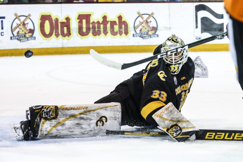men's hockey players compete in game at indoor arena