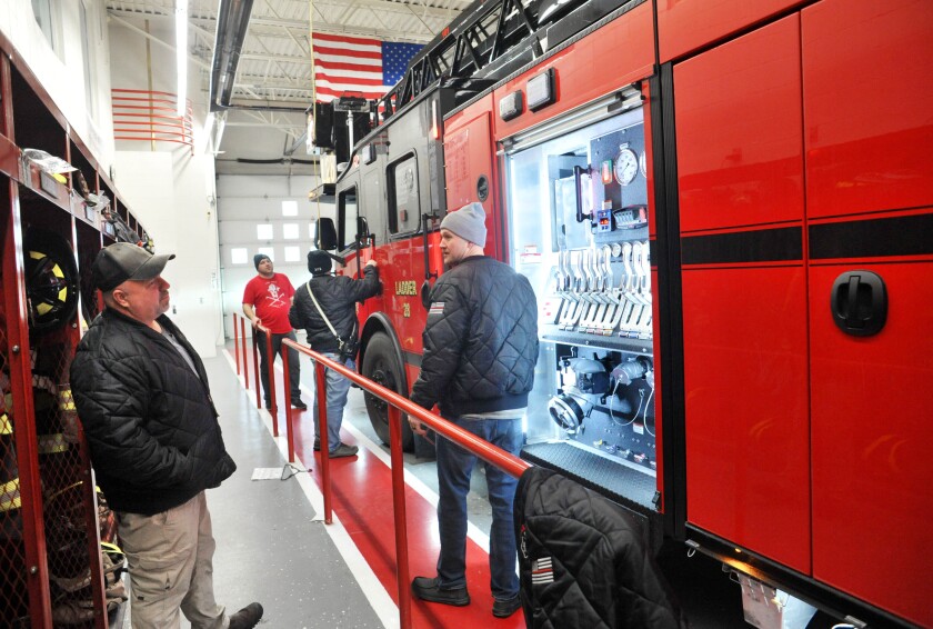 Firemen looking at fire truck