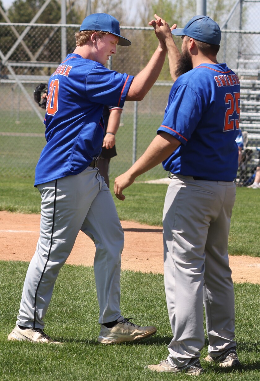 Worthington Cubs player-manager Ryan Swanson (25) gives pitcher Nathan Van Orman (20) a high five after walks load up the Bases and he pitches strike outs to end the inning.