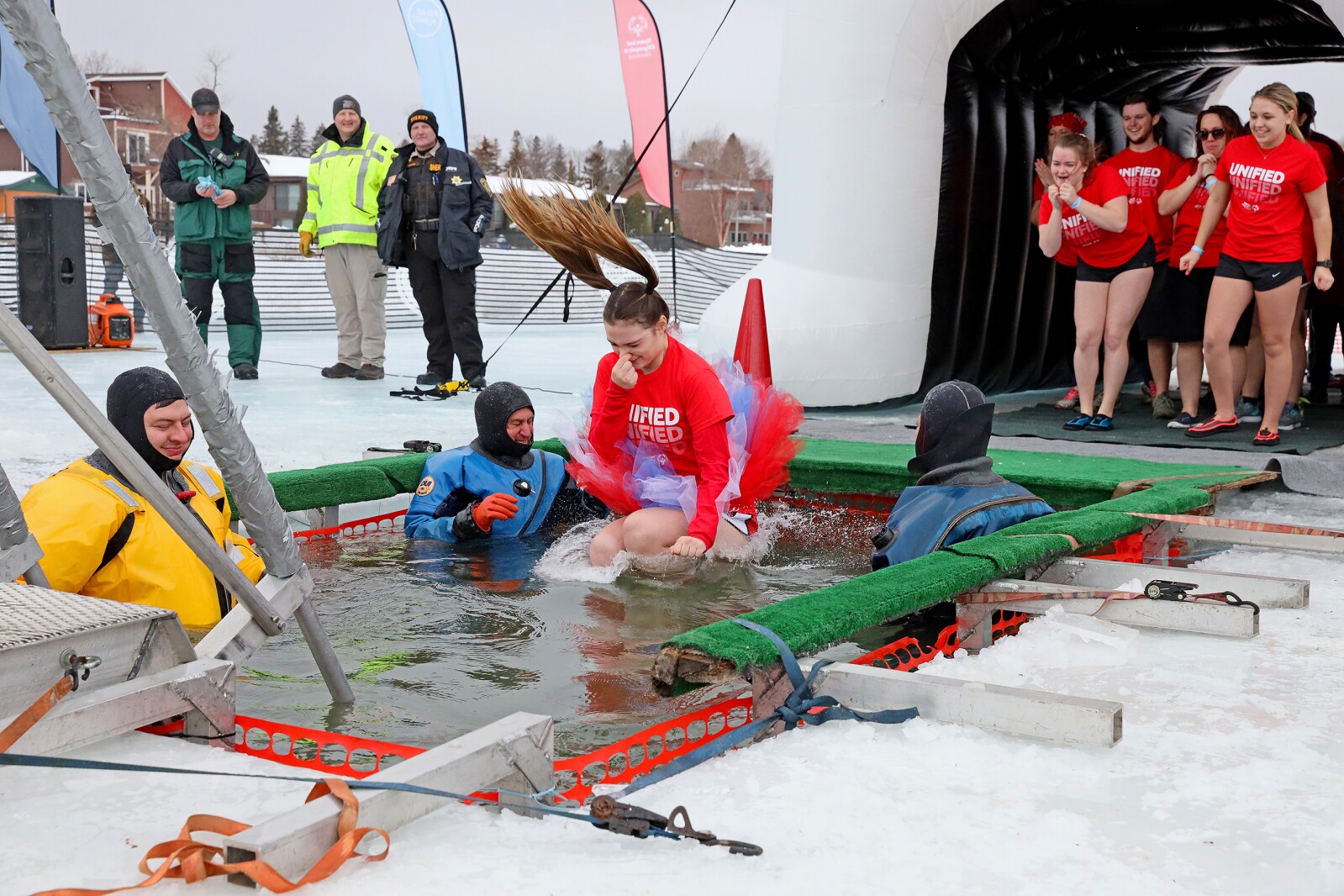 People jump into the water during the Polar Plunge event on Pelican Lake.