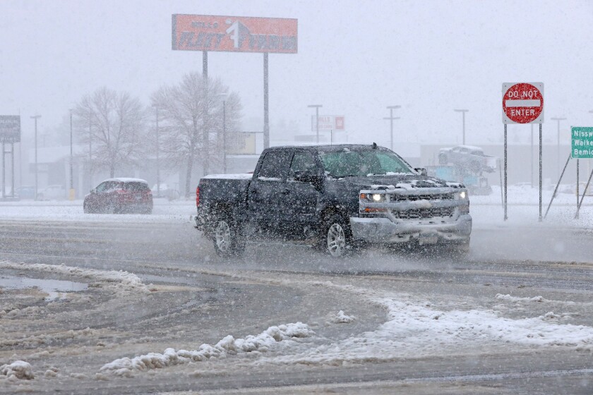 Traffic travels through slushy snow.
