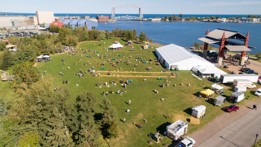 Aerial photograph of Bayfront Festival Park, showing large white tent built in front of stage, with Aerial Lift Bridge in background.