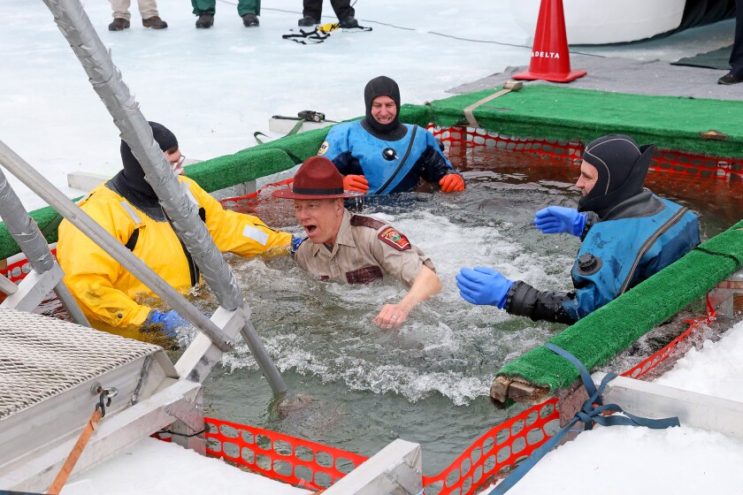 People jump into the water during the Polar Plunge event on Pelican Lake.