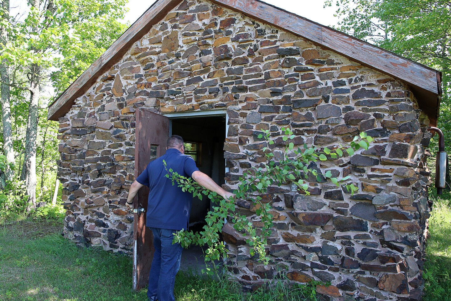 Man enters stone shed.