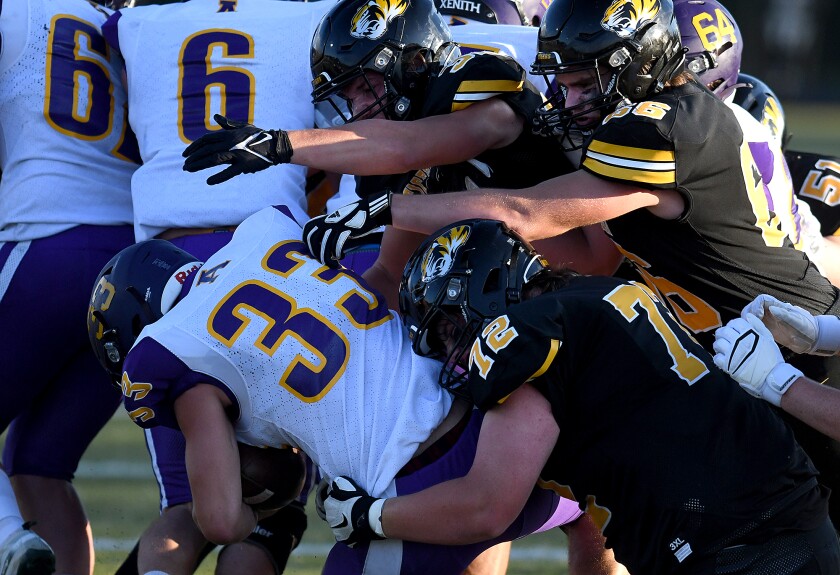 Northwestern’s Andrew Bourque (72), Peyton Kurtz (66) and Wyatt Dumonson (32) smother Ashland’s Hunter Chenier (33) behind the line of scrimmage