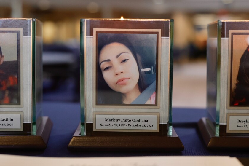 A plaque and candle with a portrait of Marleny Pinto Orellana.
