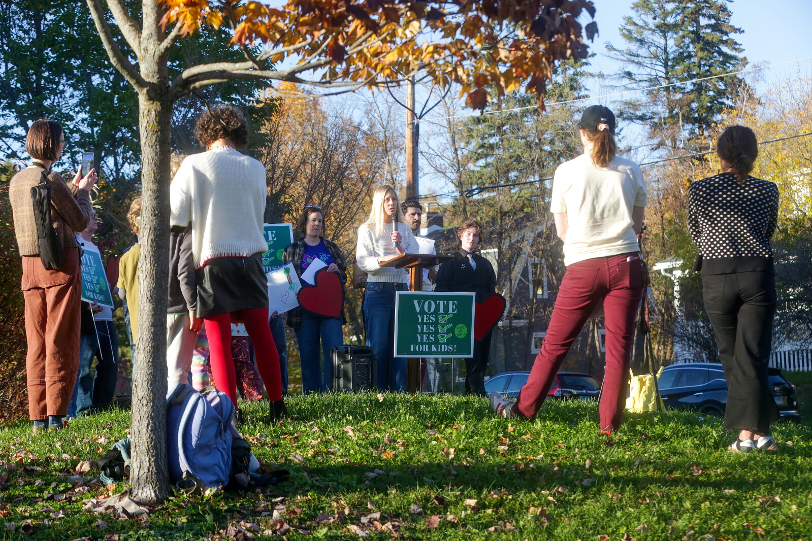 A woman speaking at a podium during an outdoor rally.