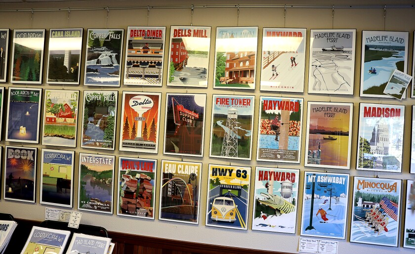 Posters of Wisconsin destinations by artist Jamey Penney-Ritter line a wall in her studio