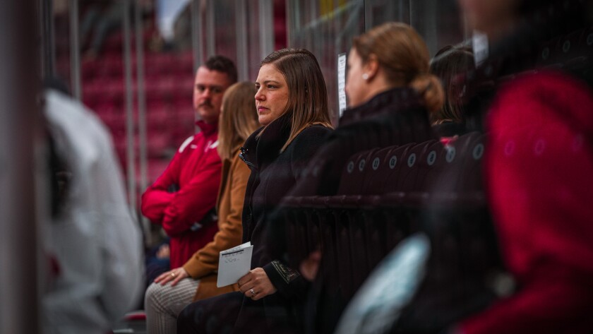 Coaching looks on from hockey bench