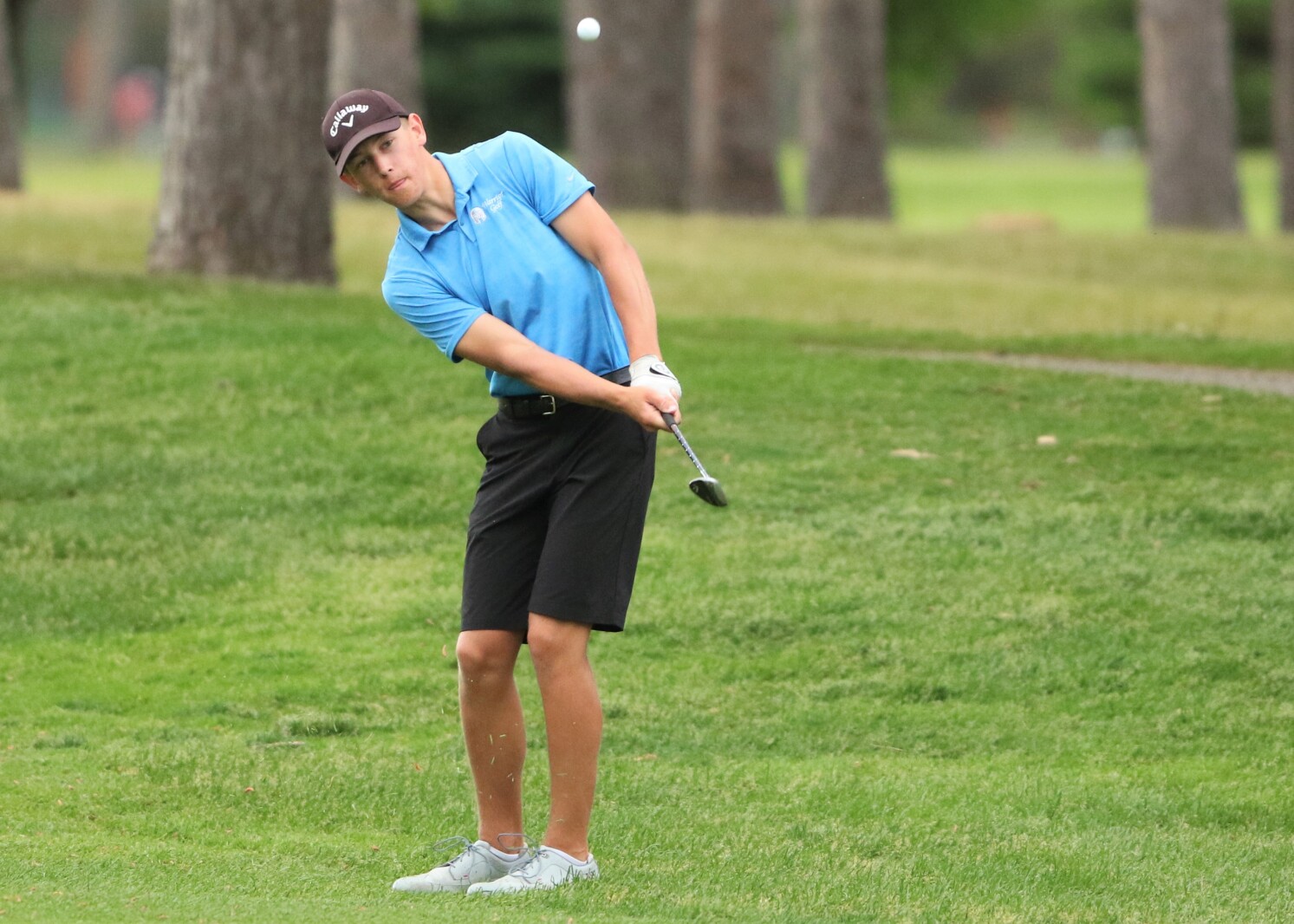 Golfer hits the ball.