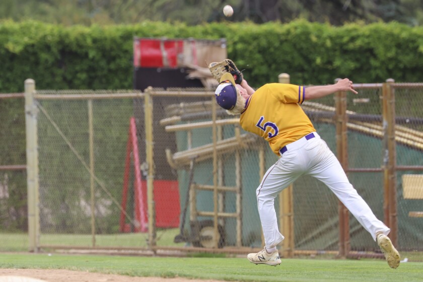 High school baseball players play on outdoor field on sunny day