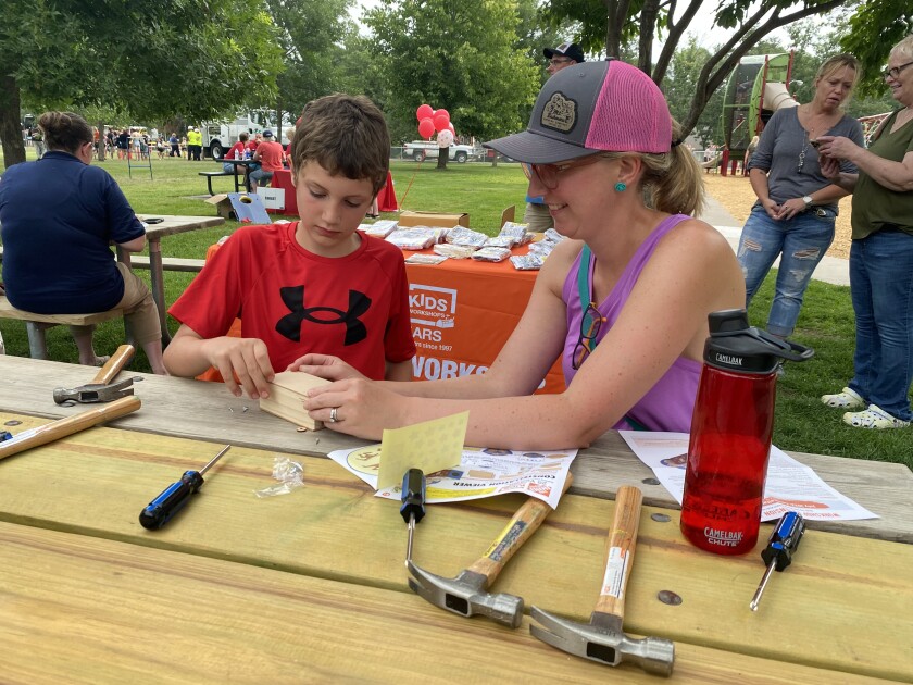 a mother and son work on a wood project