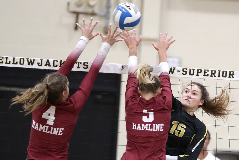 UW-Superior’s Maiana Stark (15) hits the ball past the Hamline block of Lindsay Eckelman (4) and Julianna Boyum (5)