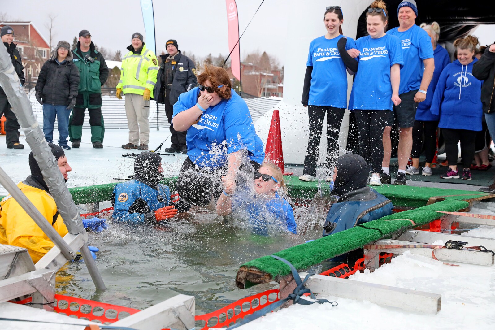 People jump into the water during the Polar Plunge event on Pelican Lake.